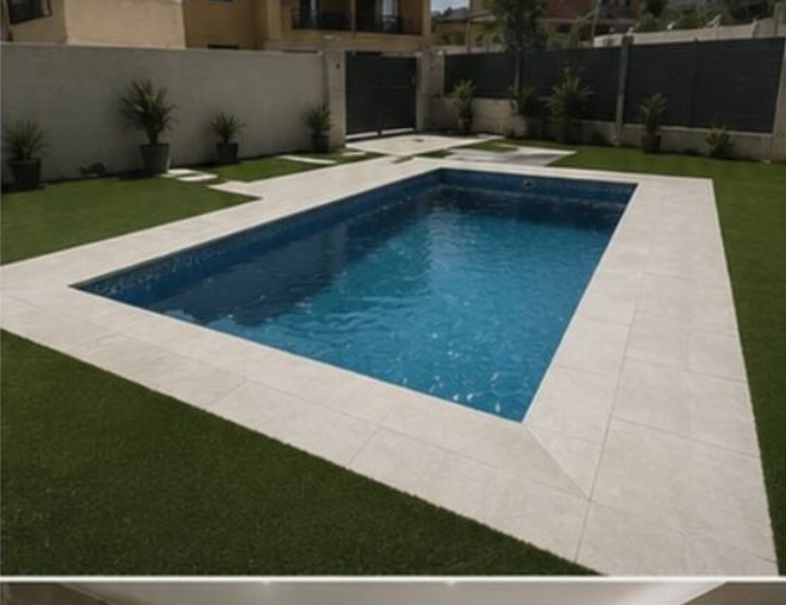 Piscina terminada con solado, césped y jardín acabado