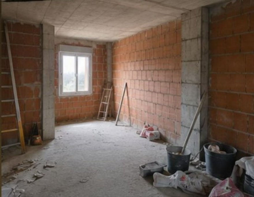 Salón de vivienda en obra, con paredes de ladrillo antes de la reforma